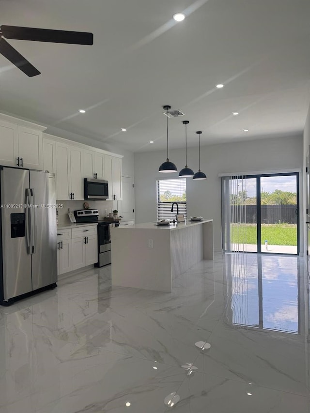 2903 W 64th St, Lehigh Acres, FL 33971 - kitchen featuring appliances with stainless steel finishes, light marble finish floors, white cabinets, recessed lighting, and pendant lighting