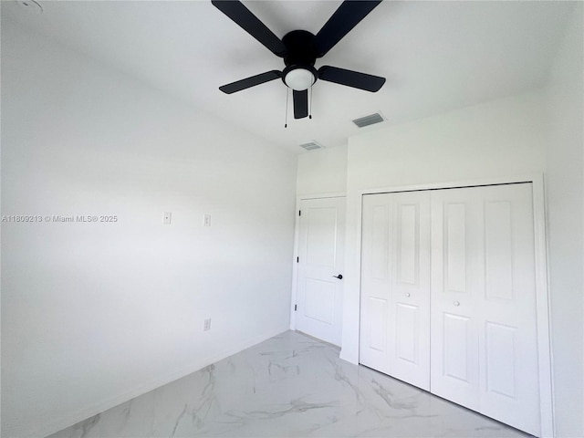 2903 W 64th St, Lehigh Acres, FL 33971 - unfurnished bedroom featuring marble look tiles, a closet, baseboards, and a ceiling fan