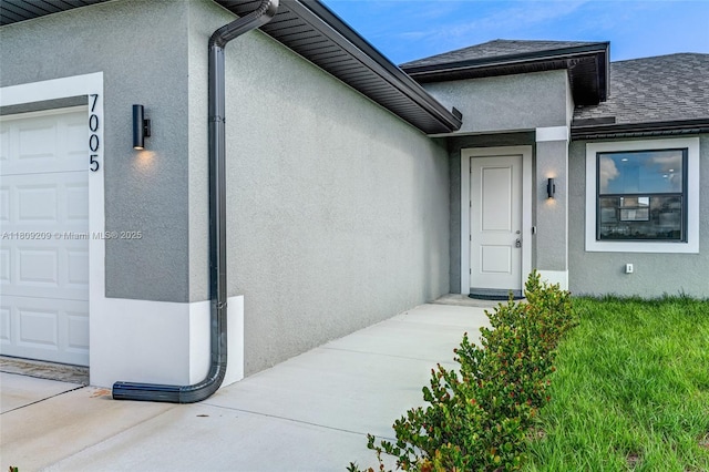 8106 Olive Ct, La Belle, FL 33935 - doorway to property featuring stucco siding, a garage, and roof with shingles