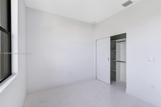 8106 Olive Ct, La Belle, FL 33935 - unfurnished bedroom with marble finish floors, baseboards, and a closet