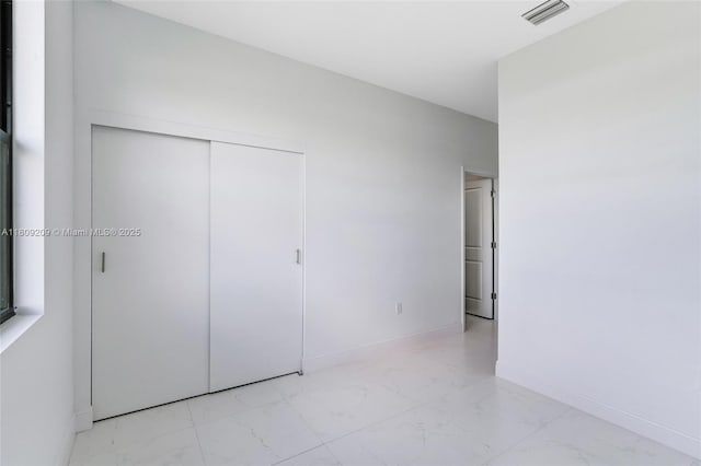 8106 Olive Ct, La Belle, FL 33935 - unfurnished bedroom featuring marble finish flooring, a closet, and baseboards