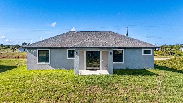 8106 Olive Ct, La Belle, FL 33935 - back of property with stucco siding, roof with shingles, and a yard