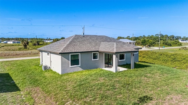 8106 Olive Ct, La Belle, FL 33935 - rear view of property with stucco siding, cooling unit, roof with shingles, a yard, and a patio area