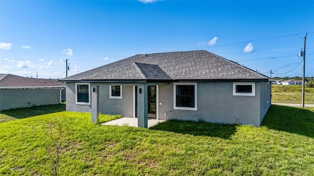 8106 Olive Ct, La Belle, FL 33935 - back of property with roof with shingles, stucco siding, and a yard