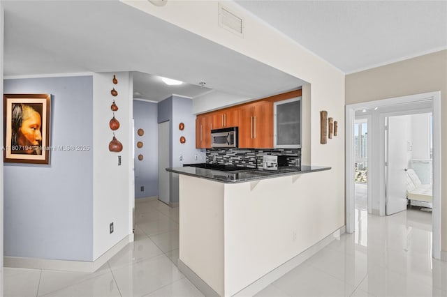 325 S Biscayne Blvd Unit 3926, Miami, FL 33131 - kitchen with brown cabinetry, stainless steel microwave, decorative backsplash, baseboards, and a breakfast bar