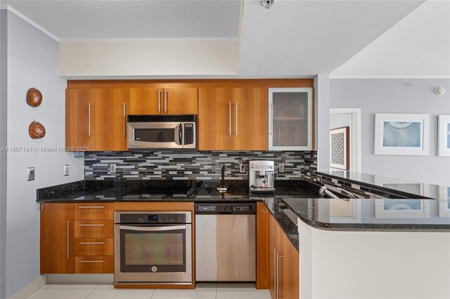 325 S Biscayne Blvd Unit 3926, Miami, FL 33131 - kitchen with appliances with stainless steel finishes, brown cabinets, dark stone countertops, backsplash, and ornamental molding