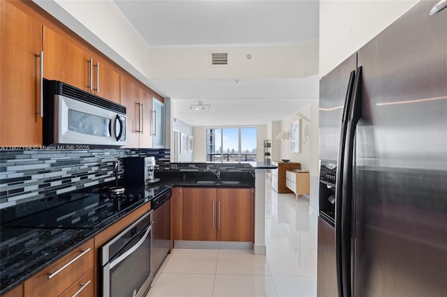 325 S Biscayne Blvd Unit 3926, Miami, FL 33131 - kitchen featuring stainless steel appliances, brown cabinets, a peninsula, light tile patterned flooring, and a sink