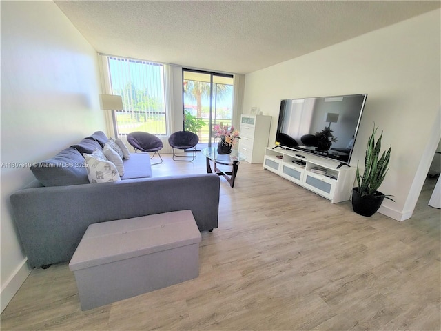 7950 W Mcnab Rd Unit 214, Tamarac, FL 33321 - living room featuring light wood-style floors, floor to ceiling windows, a textured ceiling, and baseboards