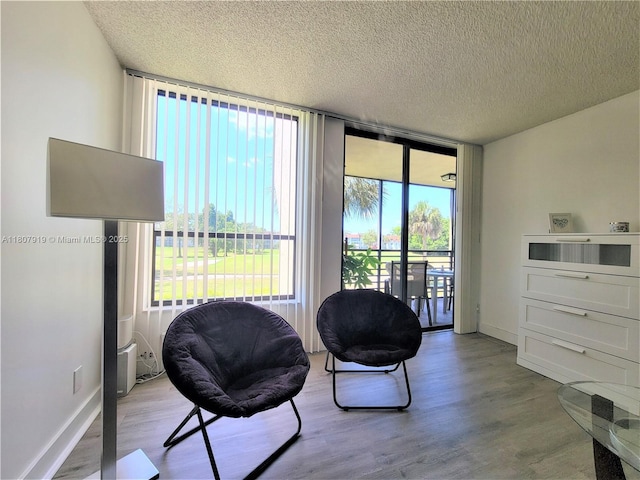 7950 W Mcnab Rd Unit 214, Tamarac, FL 33321 - sitting room with a textured ceiling, a wall of windows, wood finished floors, and baseboards