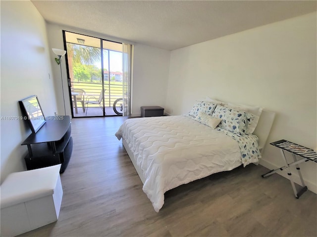 7950 W Mcnab Rd Unit 214, Tamarac, FL 33321 - bedroom with wood finished floors, a wall of windows, access to exterior, and baseboards