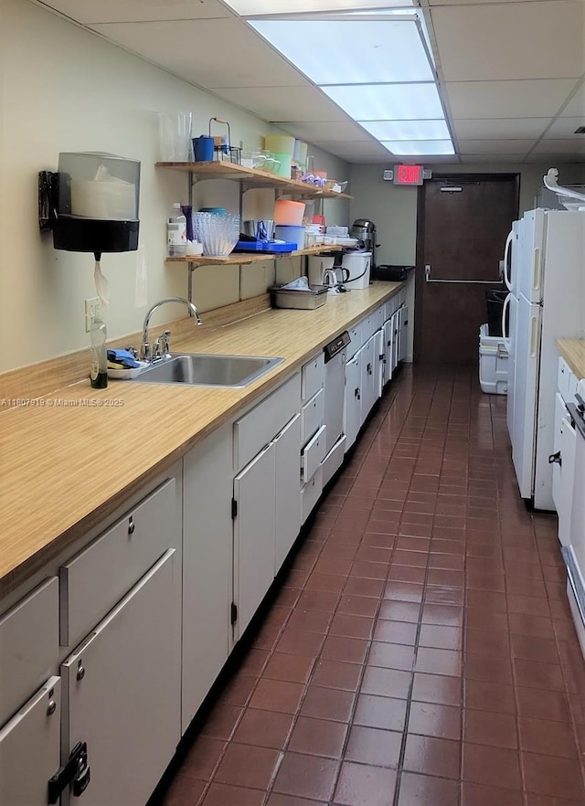 7950 W Mcnab Rd Unit 214, Tamarac, FL 33321 - kitchen with freestanding refrigerator, a sink, a drop ceiling, light countertops, and dark tile patterned floors