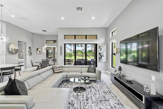 12065 N Kalmar Cir N, Parkland, FL 33076 - living area featuring light wood finished floors, recessed lighting, baseboards, a high ceiling, and a chandelier