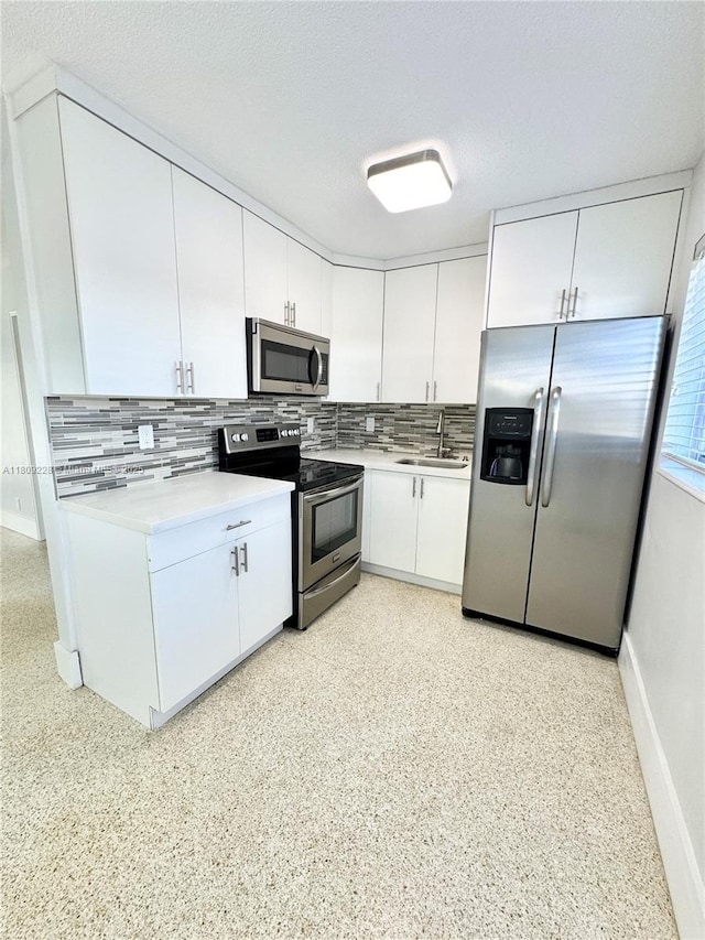 1601 SE 15th St Unit 1B, Fort Lauderdale, FL 33316 - kitchen with appliances with stainless steel finishes, a sink, decorative backsplash, white cabinets, and a textured ceiling