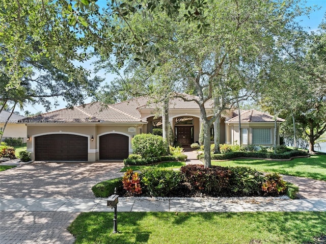 13990 SW 41st St, Davie, FL 33330 - mediterranean / spanish-style house with stucco siding, an attached garage, decorative driveway, a tile roof, and a front yard