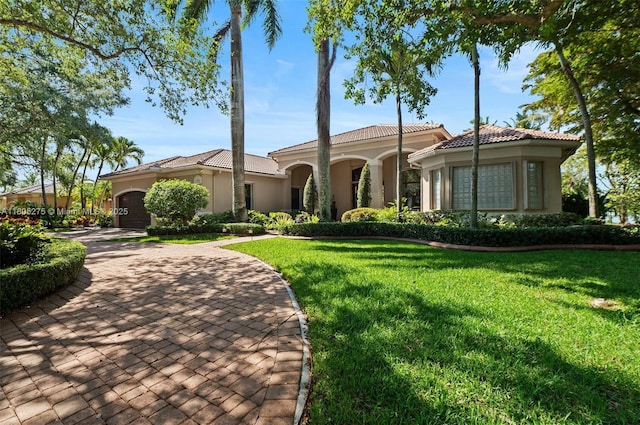 13990 SW 41st St, Davie, FL 33330 - mediterranean / spanish-style house featuring stucco siding, a front lawn, a garage, and a tiled roof