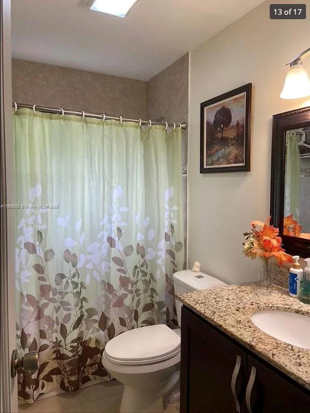 9315 SW 170th Ln, Palmetto Bay, FL 33157 - bathroom featuring vanity, toilet, tile patterned floors, and a shower with curtain