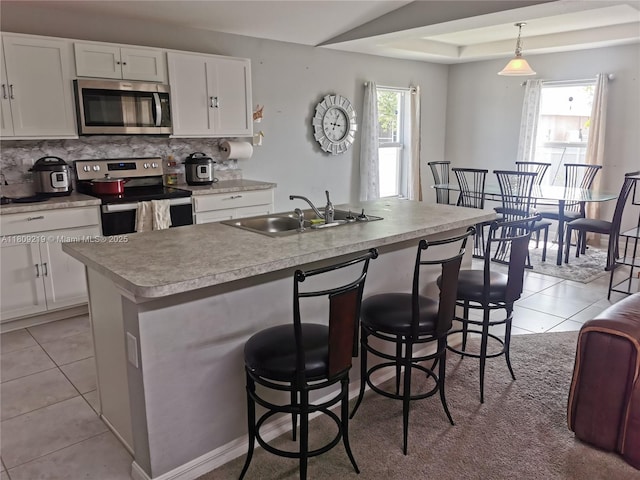 2116 5th Pl, Cape Coral, FL 33909 - kitchen with appliances with stainless steel finishes, a sink, tasteful backsplash, light tile patterned floors, and white cabinetry