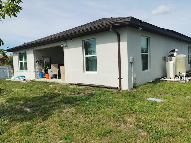 2116 5th Pl, Cape Coral, FL 33909 - back of house featuring stucco siding and a yard
