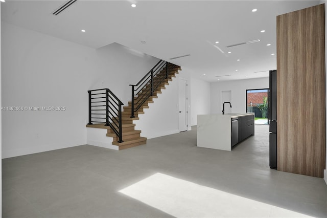 2839 SW 25th St, Miami, FL 33133 - unfurnished living room with stairway, finished concrete floors, recessed lighting, and a sink