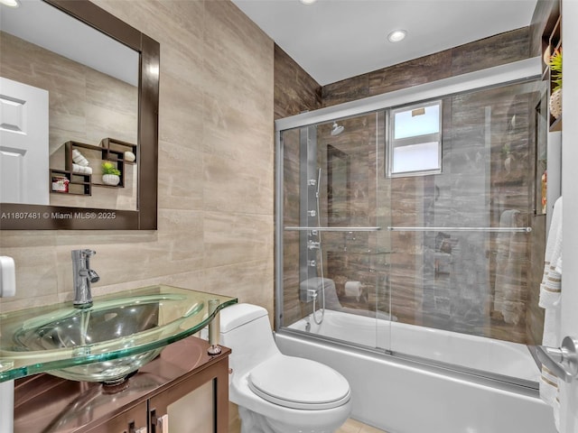 5650 W 21st Ave, Hialeah, FL 33016 - bathroom featuring tile walls, vanity, shower / bath combination with glass door, toilet, and recessed lighting