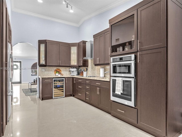 5650 W 21st Ave, Hialeah, FL 33016 - kitchen featuring wine cooler, stainless steel double oven, tasteful backsplash, ornamental molding, and arched walkways