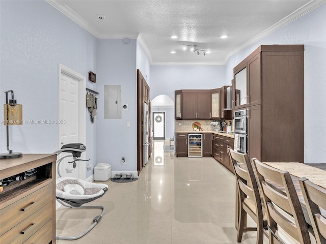 5650 W 21st Ave, Hialeah, FL 33016 - kitchen featuring beverage cooler, ornamental molding, backsplash, light countertops, and glass insert cabinets
