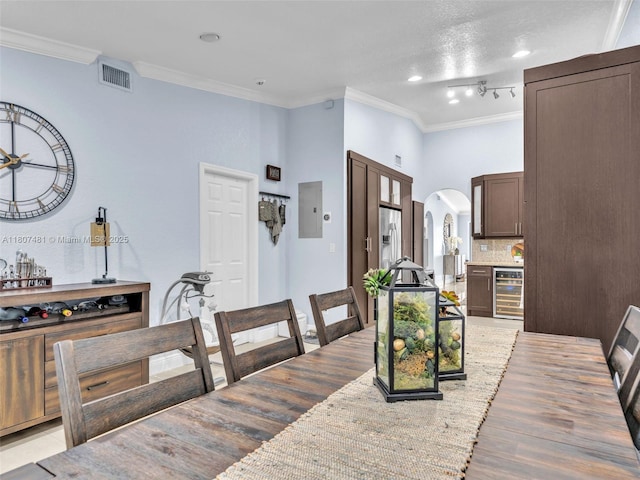 5650 W 21st Ave, Hialeah, FL 33016 - dining room with wine cooler, crown molding, arched walkways, electric panel, and light wood-type flooring