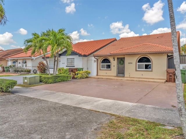 5650 W 21st Ave, Hialeah, FL 33016 - mediterranean / spanish house with a tiled roof, stucco siding, and driveway