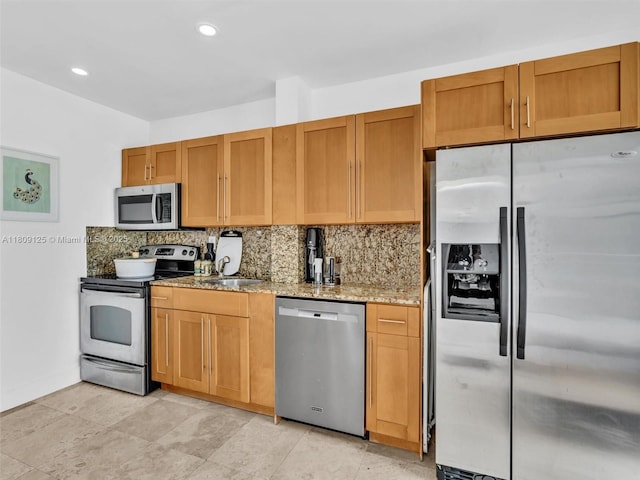 945 Michigan Ave Unit 8, Miami Beach, FL 33139 - kitchen featuring appliances with stainless steel finishes, light stone counters, tasteful backsplash, a sink, and recessed lighting