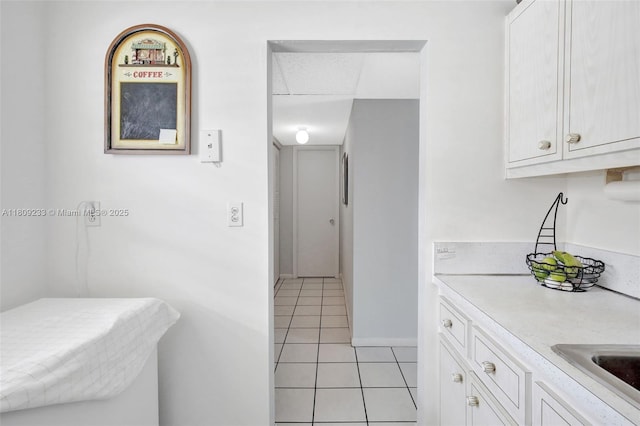 4441 NW 16th St Unit J108, Lauderhill, FL 33313 - kitchen featuring light tile patterned flooring, light countertops, white cabinets, and a sink