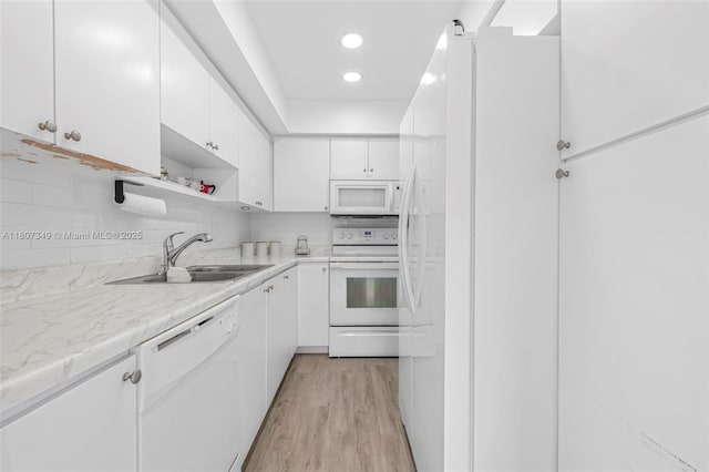 1356 Pelican Ct, Homestead, FL 33035 - kitchen featuring white appliances, a sink, white cabinets, light wood-style flooring, and tasteful backsplash