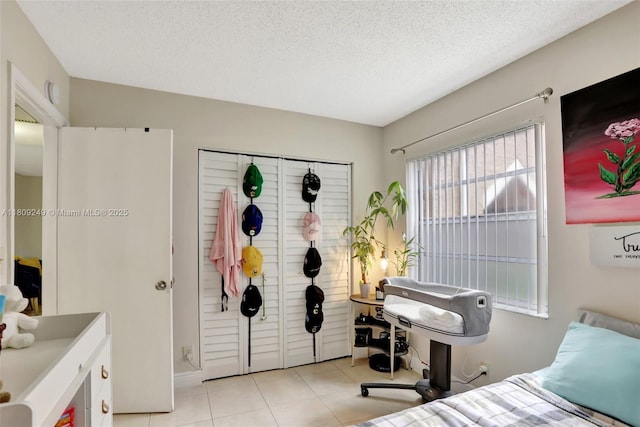 826 Twin Lakes Dr Unit 18-D, Coral Springs, FL 33071 - bedroom featuring light tile patterned floors, a textured ceiling, and a closet