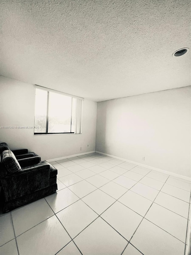 4545 Luxemburg Ct Unit 103, Lake Worth, FL 33467 - unfurnished living room with a textured ceiling, tile patterned flooring, and baseboards
