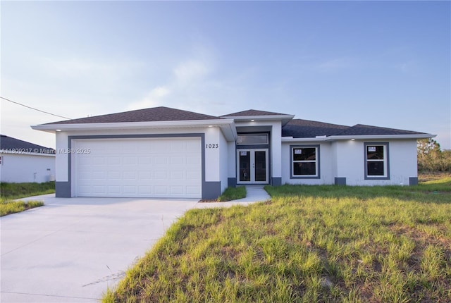 1023 Pilgrim, Lehigh Acres, FL 33974 - view of front of home featuring french doors, stucco siding, driveway, and an attached garage