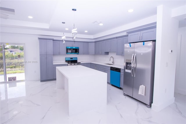 1023 Pilgrim, Lehigh Acres, FL 33974 - kitchen with stainless steel appliances, a sink, light countertops, decorative light fixtures, and a kitchen island