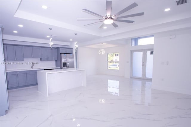 1023 Pilgrim, Lehigh Acres, FL 33974 - kitchen with stainless steel fridge, recessed lighting, a sink, a tray ceiling, and a kitchen island