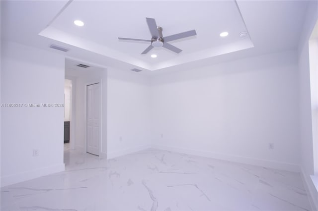 1023 Pilgrim, Lehigh Acres, FL 33974 - unfurnished room with a tray ceiling, baseboards, ceiling fan, recessed lighting, and light marble finish floors