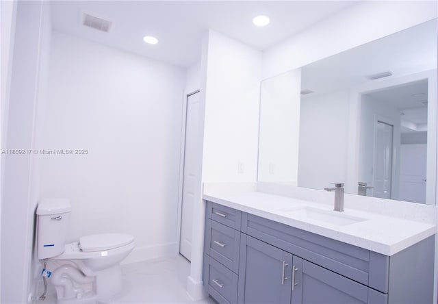 1023 Pilgrim, Lehigh Acres, FL 33974 - bathroom with vanity, toilet, baseboards, marble finish flooring, and recessed lighting
