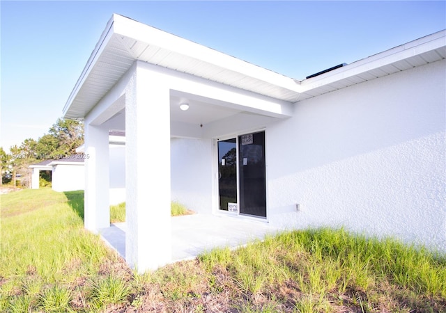 1023 Pilgrim, Lehigh Acres, FL 33974 - entrance to property with stucco siding, a lawn, and a patio area