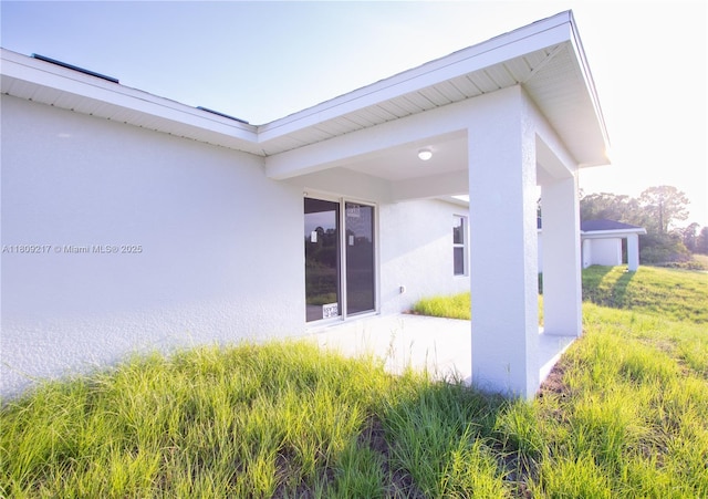 1023 Pilgrim, Lehigh Acres, FL 33974 - back of house with stucco siding and a patio