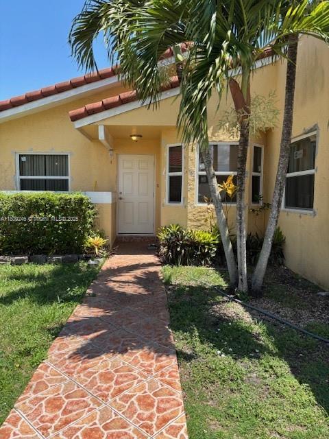 10813 SW 158th Ln, Miami, FL 33157 - entrance to property with stucco siding and a lawn