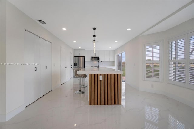10728 Oak Lake Way, Boca Raton, FL 33498 - kitchen featuring appliances with stainless steel finishes, light marble finish floors, white cabinetry, a kitchen island with sink, and recessed lighting