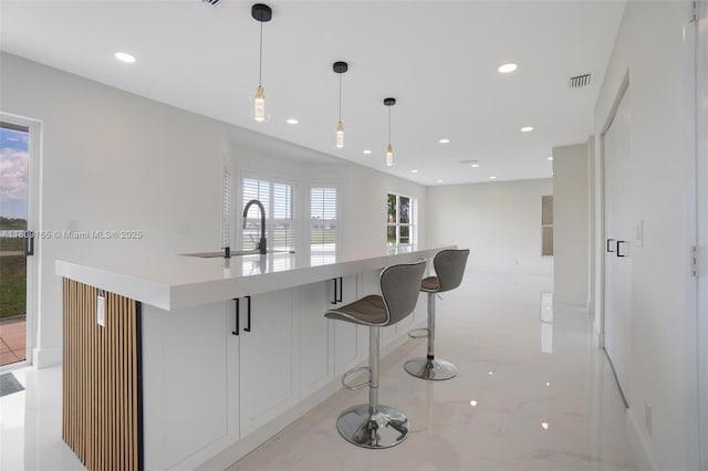 10728 Oak Lake Way, Boca Raton, FL 33498 - kitchen featuring a sink, light marble finish floors, recessed lighting, hanging light fixtures, and light countertops