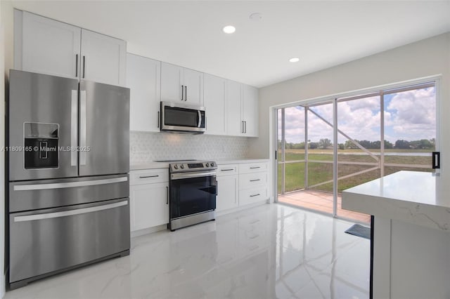 10728 Oak Lake Way, Boca Raton, FL 33498 - kitchen featuring appliances with stainless steel finishes, backsplash, recessed lighting, light marble finish flooring, and white cabinets