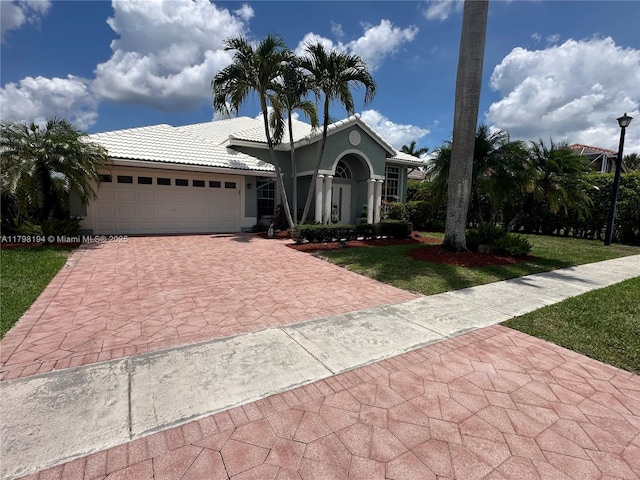 19401 Preserve Dr, Boca Raton, FL 33498 - view of front of property with decorative driveway, a tiled roof, a garage, a front yard, and stucco siding