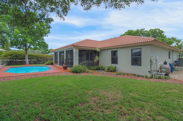 17375 SW 282nd St, Homestead, FL 33030 - rear view of property featuring a sunroom, stucco siding, a lawn, a tile roof, and central AC