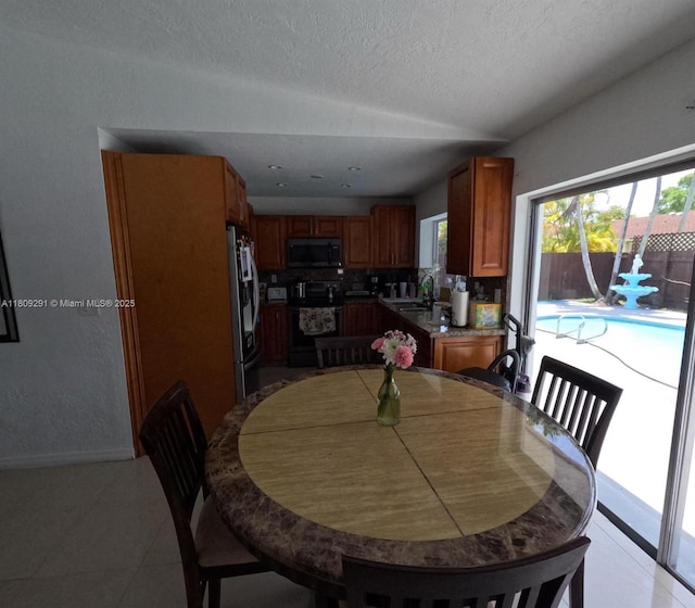13320 SW 99th St, Miami, FL 33186 - dining room featuring a textured ceiling, plenty of natural light, light tile patterned floors, and baseboards