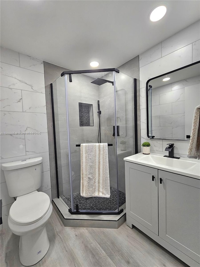 1490 NW 43rd Ave Unit 301, Lauderhill, FL 33313 - bathroom featuring tile walls, vanity, toilet, wood finished floors, and a stall shower