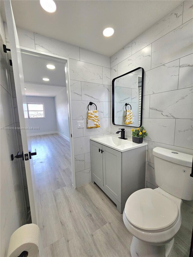1490 NW 43rd Ave Unit 301, Lauderhill, FL 33313 - bathroom with vanity, toilet, wood finished floors, tile walls, and recessed lighting