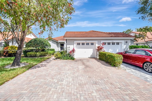 7713 Springwater Pl, Boynton Beach, FL 33437 - view of front of home with a tile roof, an attached garage, stucco siding, and decorative driveway